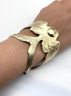 A beautiful Swallow design from the Art Nouveau period. Created from a vintage finding it is made from brass which has been highly polished. It is nickel free and hypoallergenic. It fits a medium sized wrist and has a total circumference is 7 inches. It can be adjusted to fit the size of the person wearing it. Nickel-free Antique Gold Metal Jewelry, Unique Brass Cuff Bracelet For Formal Occasions, Elegant Antique Gold Brass Bracelet, Collectible Gold-tone Brass Jewelry, Nickel-free Bronze Bracelet Jewelry, Vintage Hand Cast Jewelry For Weddings, Antique Gold-tone Bracelets For Gift, Vintage Hand Cast Jewelry For Wedding, Adjustable Gold-tone Brass Jewelry