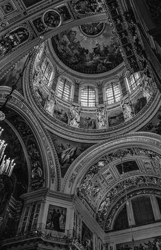 black and white photograph of the interior of a building with ornate paintings on the ceiling