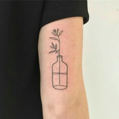 a black and white photo of a bottle with a plant in it on the arm