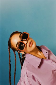 a woman with dreadlocks and sunglasses on her face