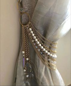 a dress with pearls and chains hanging from it's back