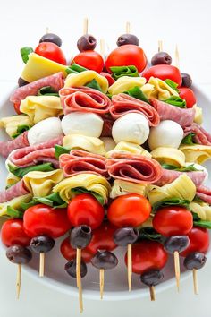 a platter filled with meat and veggies on skewered toothpicks