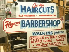 two signs advertising barbershop sit on the floor