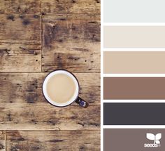 a cup of coffee sitting on top of a wooden table next to a color swatch