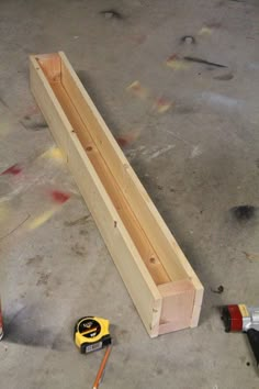 some tools are laying on the floor next to wooden planks