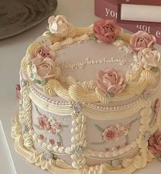 a decorated birthday cake sitting on top of a table next to a stack of books