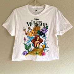 the little mermaid t - shirt hanging on a wall