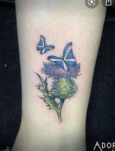 a thistle flower and butterfly tattoo on the ankle