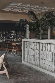 an empty restaurant with tables and chairs next to palm trees in the middle of the room