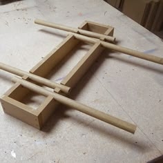 three wooden sticks sitting on top of a table next to another piece of art work