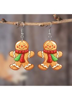 two gingerbreads are hanging from a branch