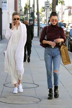 two women walking down the street talking on their cell phones