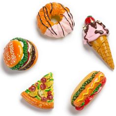 four different shaped doughnuts are arranged in a circle on a white surface, including one with an ice cream cone