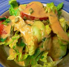 a blue and white plate topped with salad covered in dressing