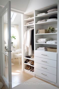 an open closet with white drawers and clothes