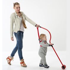 a woman holding the handle of a small child's walking cane while standing next to her