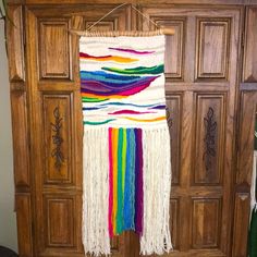 a colorful wall hanging on the side of a wooden door