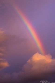 a rainbow in the sky with clouds