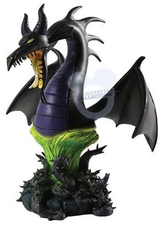 a black and green dragon statue sitting on top of a rock