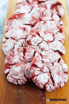 red velvet cookies on a wooden cutting board covered in powdered sugar and powdered sugar