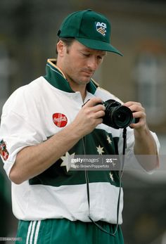 a man in green and white holding a camera