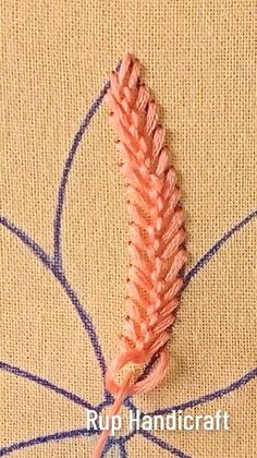 a close up of an orange flower on a piece of fabric with the words rup handicraft written below it