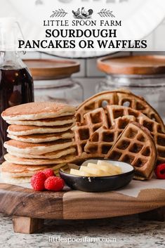 a stack of waffles sitting on top of a cutting board next to syrup