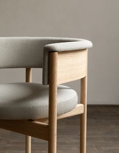 an upholstered chair sits in front of a wall