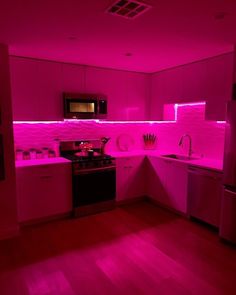 the kitchen is lit up with pink lighting