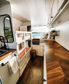 the interior of an rv with wood flooring and white walls, including bunk beds