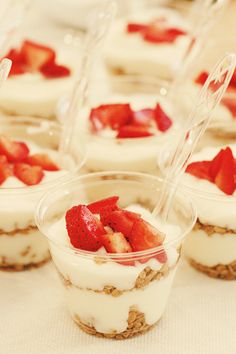 small desserts with strawberries and yogurt in plastic cups on a table