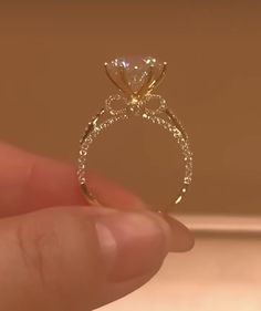 a person holding a diamond ring in their hand