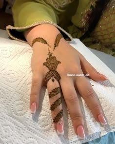 a woman's hand with henna tattoos on it