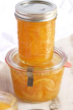 two jars filled with yellow liquid sitting on top of a table