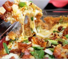 a close up of a pizza being lifted with a fork from a casserole dish