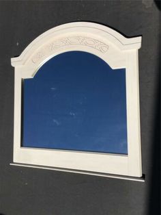 the reflection of a blue sky and clouds in a mirror on a black door frame