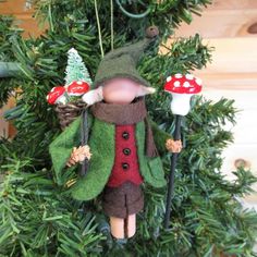 a christmas ornament hanging from a tree with mushrooms and gnomes on it