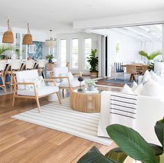 a living room filled with lots of furniture and plants