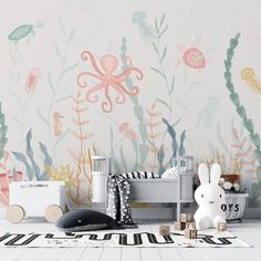 a child's room decorated in pastel colors with an octopus and seaweed wallpaper