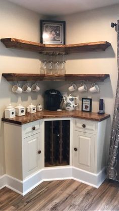 a kitchen with white cabinets and wooden shelves on the wall next to a wine glass rack