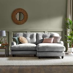 a blue couch in a living room next to a table with a mirror on it