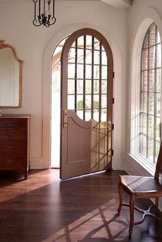 an entryway with arched glass doors and wooden flooring is seen in this image