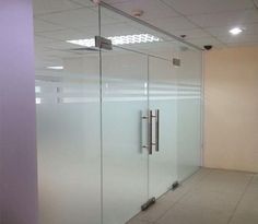 an empty room with glass walls and doors