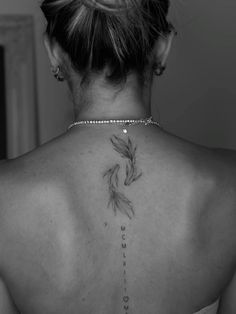 the back of a woman's neck with a goldfish tattoo