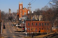 an old brick building sits on the corner of a street with power lines in front of it