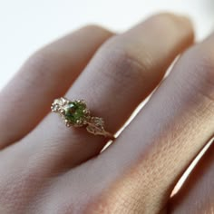 Mori 森 [もり] is the Japanese word for forestInspired by one of my favorite video game franchises of all time, this ring features a bright green peridot center stone. The stone is surrounded by tiny clovers and saplings, and on either side are two large curving leaves with round brilliant cut diamonds replacing the circular hole present in the classic Animal Crossing leaf design. CUSTOMIZE GEMSTONES ✶ solid 14 karat recycled yellow, white, or rose gold✶ band measures 1.6mm wide x 1.4mm thick✶ cent Animal Crossing Leaf, Peridot Engagement Rings, Cute Engagement Rings, Future Engagement Rings, Dream Engagement Rings, Rose Gold Band, Jewelry Lookbook, Green Peridot, Pretty Rings