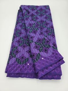 a purple and black patterned cloth on a white surface