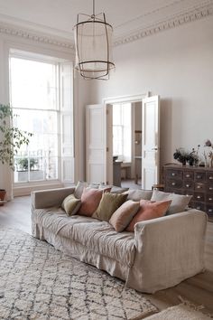 a living room filled with furniture and a chandelier hanging over the top of it