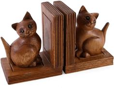 wooden bookends with cats sitting on top of each other and an open book