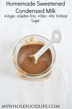 homemade sweetened condensed milk in a glass jar with a spoon on the side and text overlay